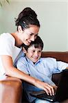 Mother and son playing with a laptop on the couch