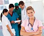 Smiling nurse with doctors in the background