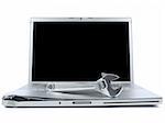 A spanner over a damaged laptop isolated over white background. Black copy space on screen.