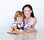 Son and mother drawing at home looking at the camera