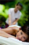 An attractive young Asian woman gets a massage outdoors