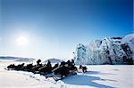 A number of snowmobiles near a glacier in Svalbard, Norway