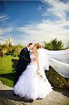 bride and groom kissing in the park