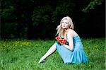 Blonde Pretty Woman Sitting On The Grass
