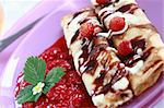 Delicious crepes with strawberry sauce and chocolate