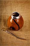 Argentinean Calabash with Bombilla over canvas background, selective focus