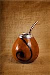 Argentinean Calabash cup with Bombilla over canvas background, selective focus