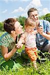 Happy family in the green sunny meadow