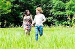 Happy loving couple running in the field