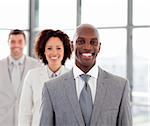 Smiling African businessman with his team in office