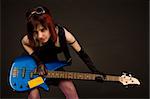 Sensual girl in crazy outfit with bass guitar, studio shot
