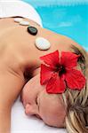 Woman at a spa with red hibiscus flower