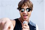 A Rock star with sunglasses and a mic jamming out