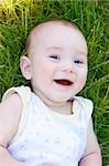 Portrait of a laughing baby lying in the grass
