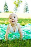 Baby in the park, crawling on the blanket