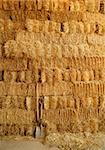 golden straw bales stacked like big wall and tools