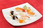 assorted sushi lying at the white square plate