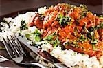 Chicken tikka masala served  with rice and garnished with cilantro leaves