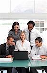 Female manager working with her team with a laptop in office