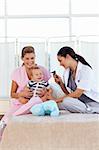 Baby playing with pediatrician and nurse in hospital