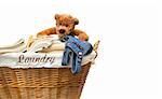 Laundry basket full of towels with teddy bear on white background