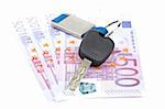 Car key and euro bills on white background with shallow depth of field