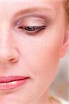 Half of woman face with a makeup macro photo with one eye half-closed