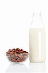 A bowl of chocolate cornflakes and milk bottle on white background.. Shallow depth of field