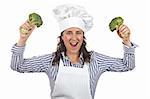 Cook woman holding two broccolis isolated on white background