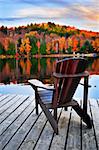 Wooden dock with chair on calm fall lake