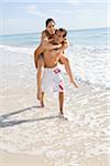 Mann Frau Piggyback ritt am Strand bei