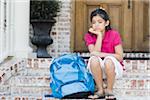 Fille avec le sac à dos, assis sur les marches