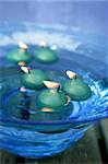 green candles over blue glass bowl of water