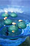 green candles over blue glass bowl of water