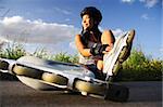 Asian woman on inline rollerblades enjoying a break.