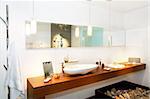 Interior of wooden bathroom with long mirror