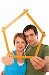 Young couple with model house of wooden meter - isolated