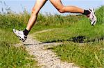 Running in nature. Freeze action closeup of running shoes and legs in action on trail.