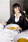 Business woman is having lobster soup and white wine at a fine restaurant