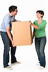 A cute couple moving a box together.  They are smiling.  Vertically framed shot.