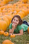 Little Girl Laying Down in the Pumpkin Patch