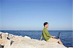 Handsome young businessman with computer on the blue ocean beach