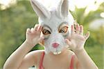 Toddler girl with rabbit white mask scaring to camera