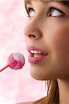 Pretty young girl with sugar on lips and a lollipop looking up