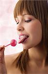Pretty young girl with sugar lips licking a pink lollipop