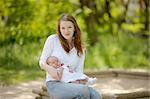 Young mother is holding her newborn baby in the arms