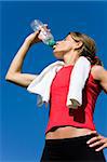 Beautiful women with towel drinking water after exercise