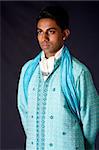 Beautiful authentic Indian hindu man in typical ethnic groom attire. Bangali male wearing a light blue agua decorated Dhoti with shawl.