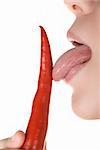 girl close up licking chili pepper  isolated on white