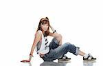 Confused young female dancer sitting on shiny floor on white background
